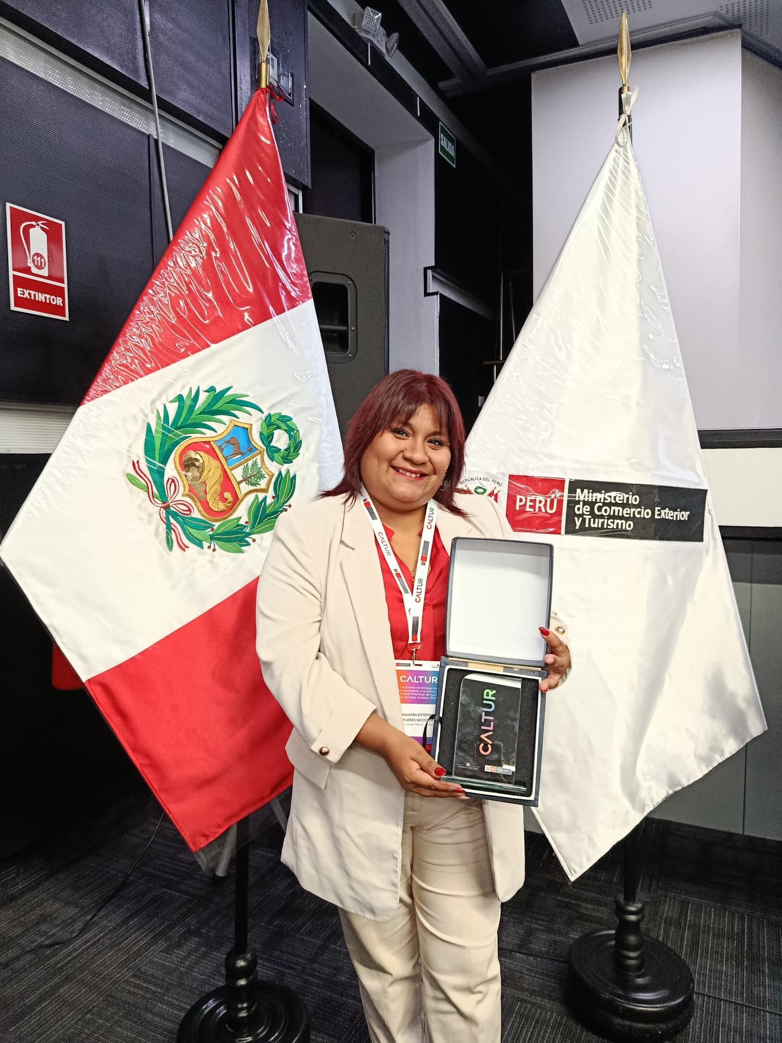 Directora KUYAIKI con reconocimiento CALTUR y bandera Perú